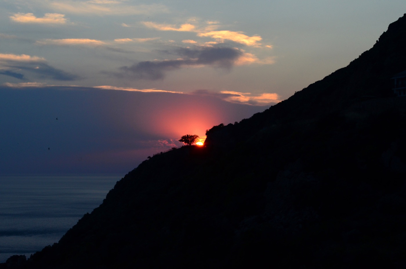 Atardecer sobre el Monte Athos visto desde el mar, con la silueta de la montaña al fondo
